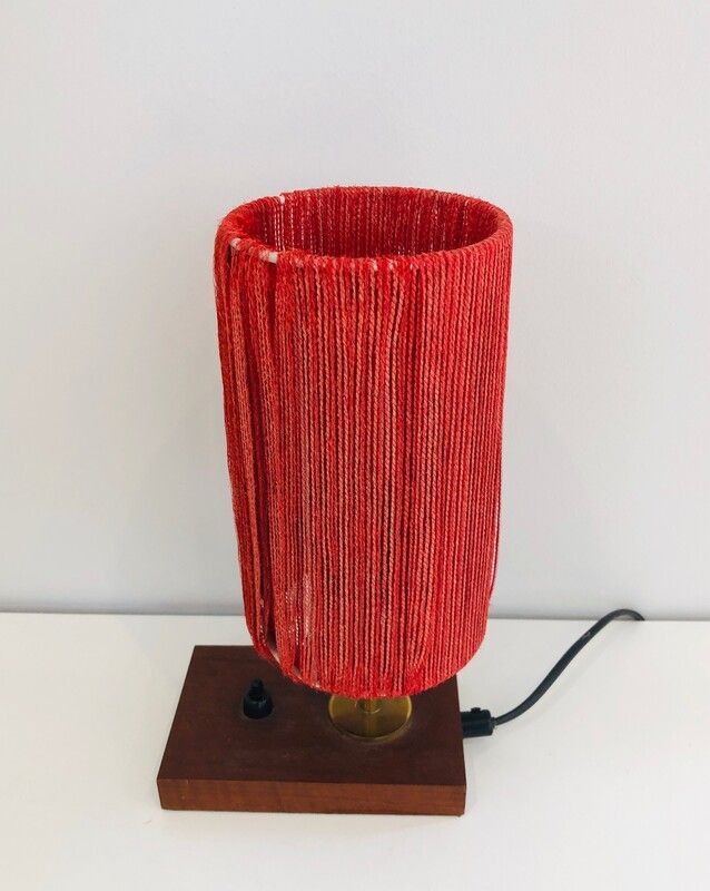 Small lamp made of wood, brass, and wool.