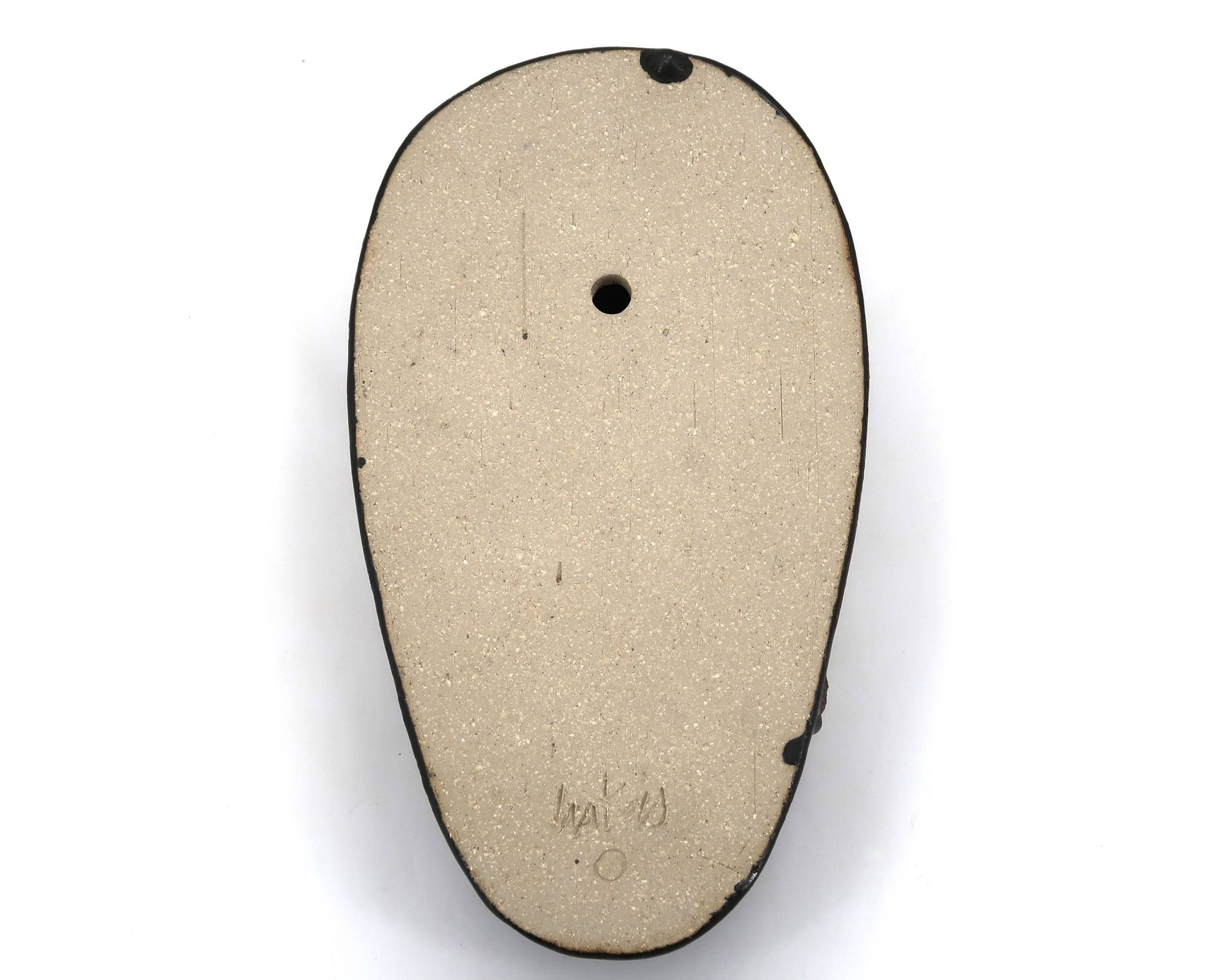 Wall sculpture, stylised mask signed in ceramic.
