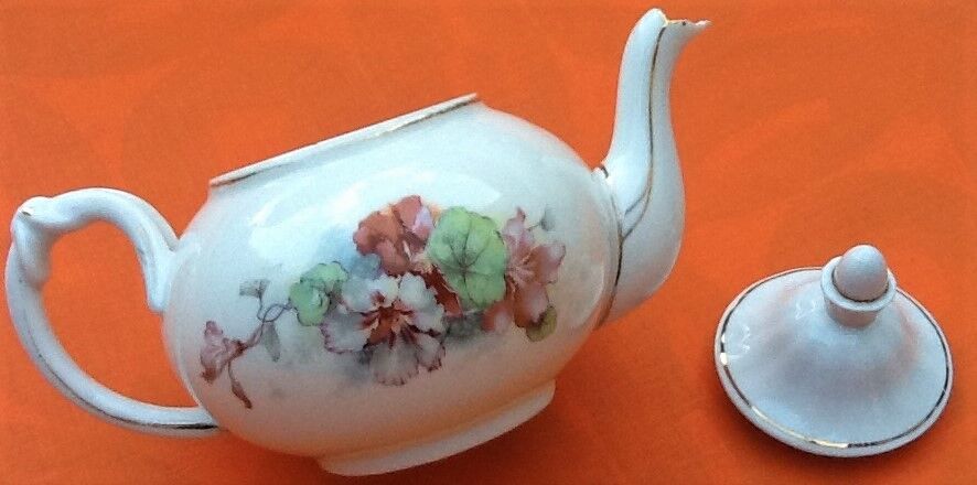 Old porcelain teapot with floral decoration