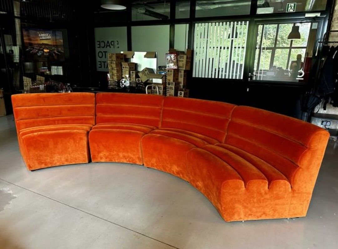 Burnt orange modular sofa for four with a futuristic design.