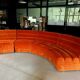 Burnt orange modular sofa for four with a futuristic design.