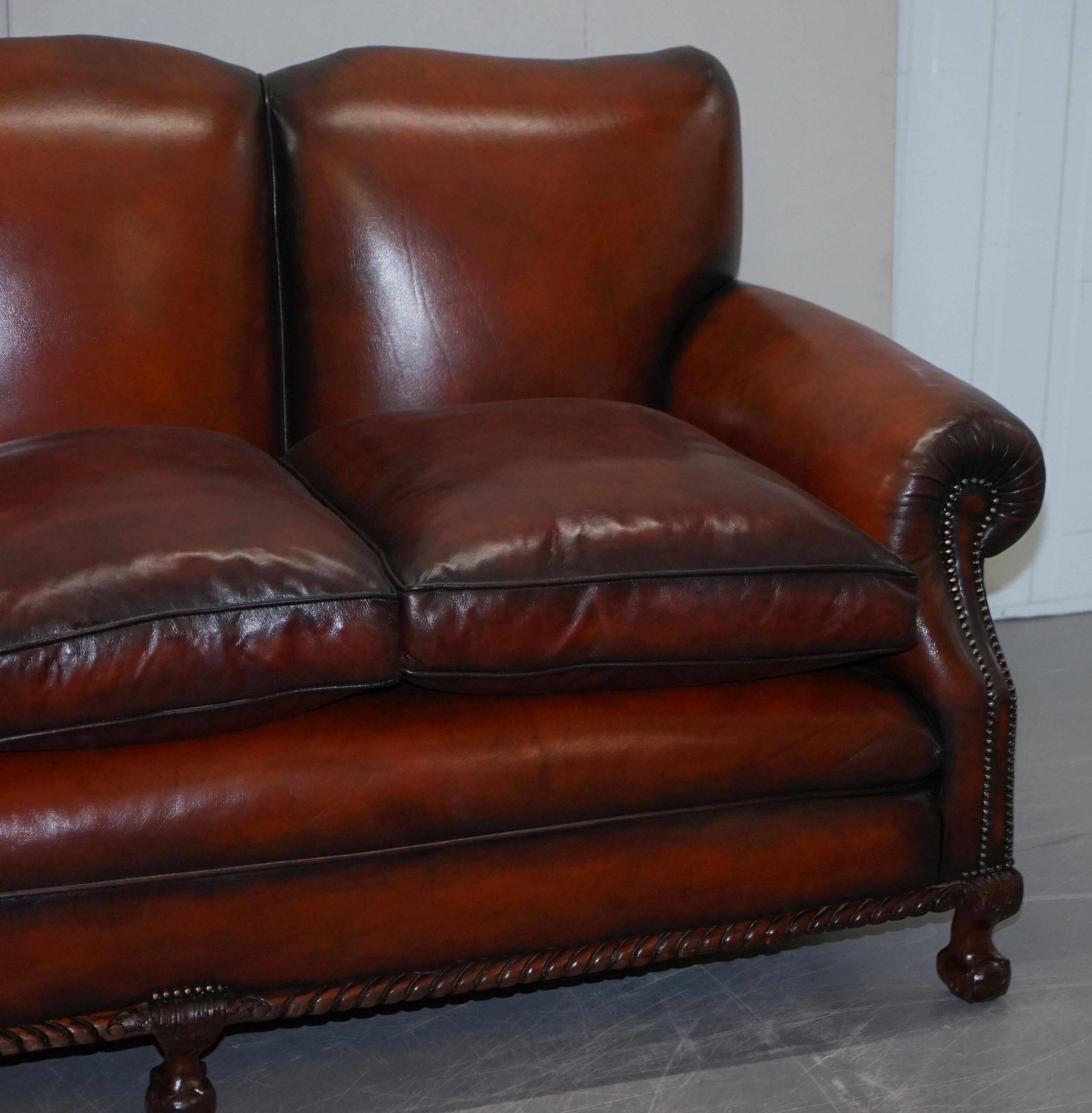 Restored Victorian sofa in leather with claw feet and feather cushions.