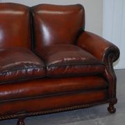 Restored Victorian sofa in leather with claw feet and feather cushions.