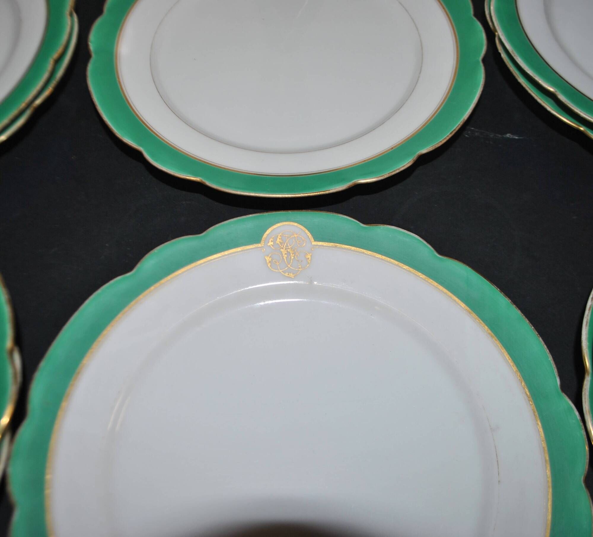 Paris porcelain set of 12 flat plates with green border and gold monogram JC.
