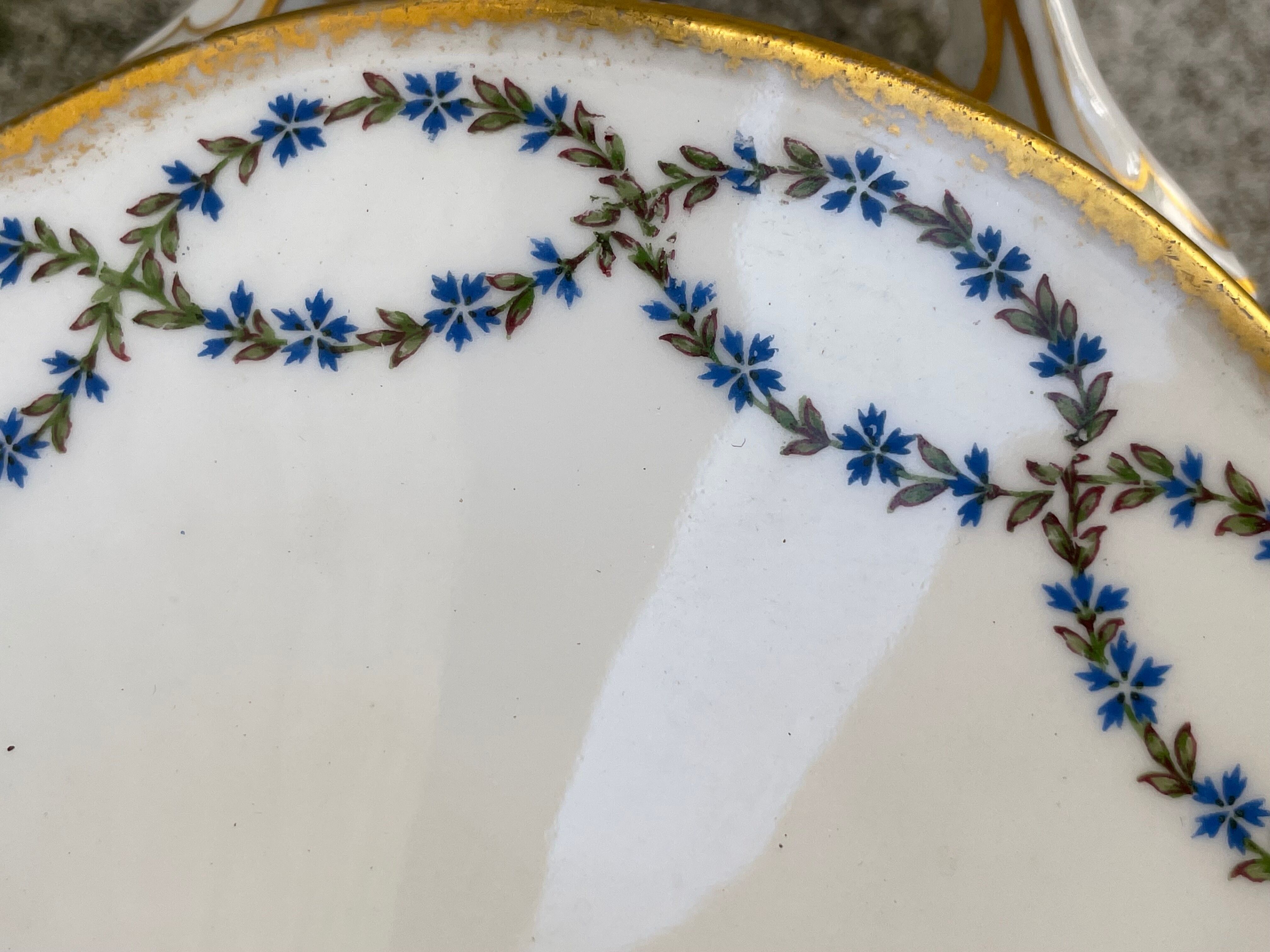Old soup bowl with a golden border and decorated with small blue flowers