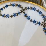 Old soup bowl with a golden border and decorated with small blue flowers