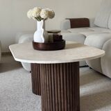 Oval coffee table in travertine and fluted wood.