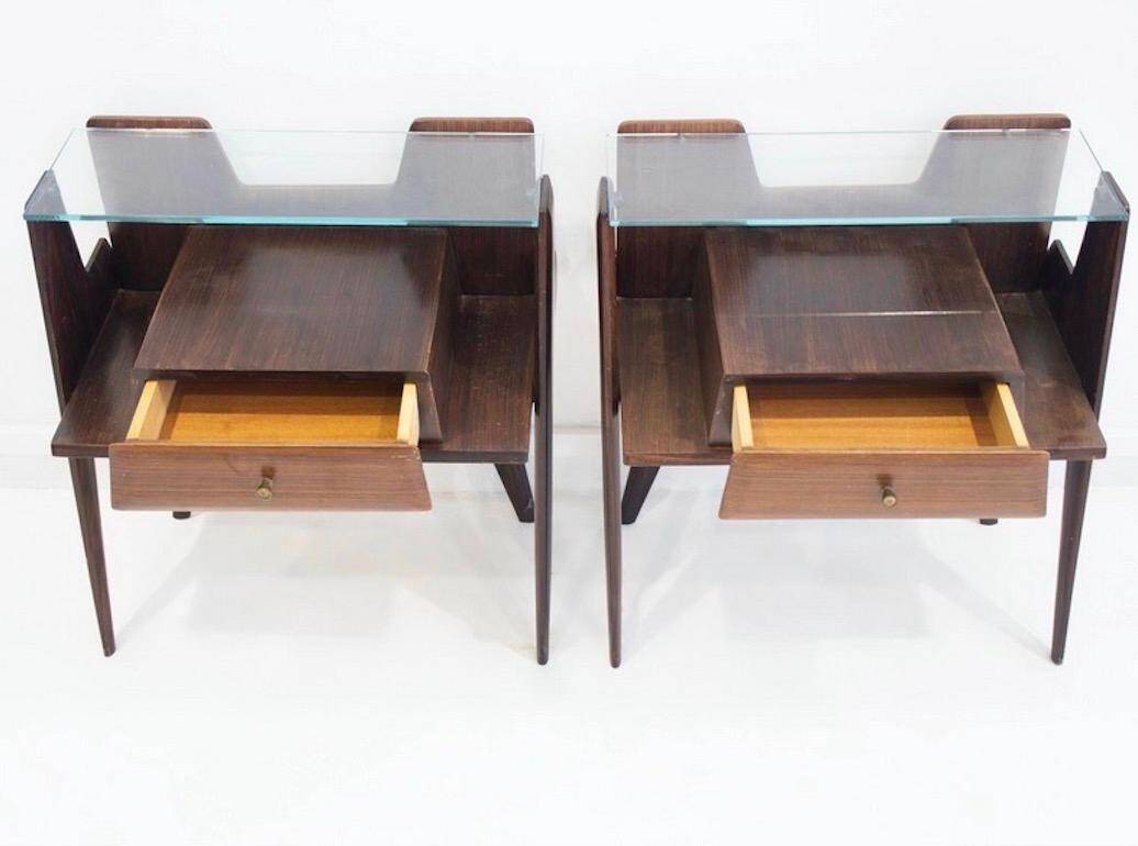 Pair of modernist Italian bedside tables in wood with a glass top.