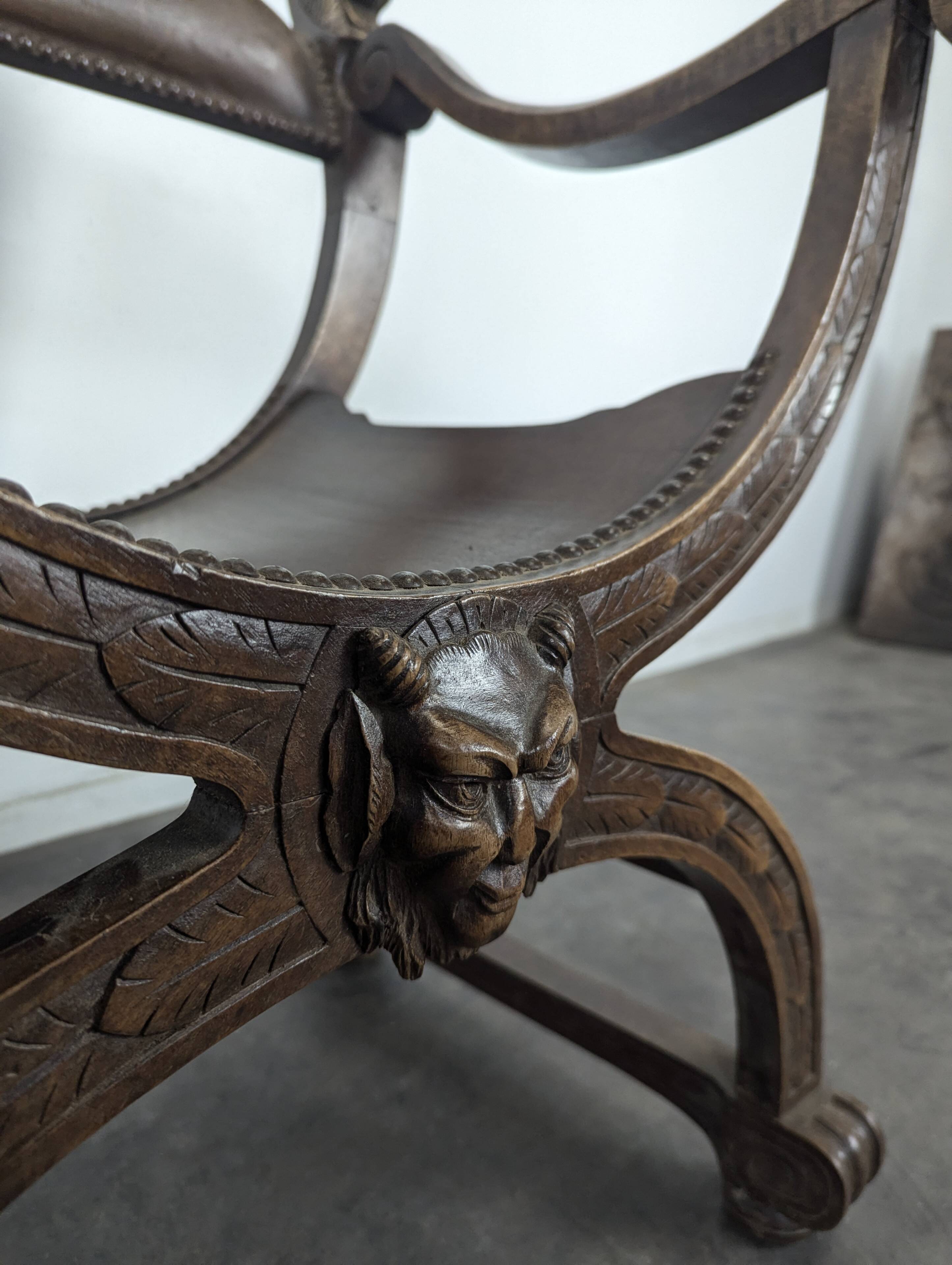 Curule chair Dagobert in carved walnut with lion heads.