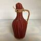 Small decorative bottle in burgundy wicker.