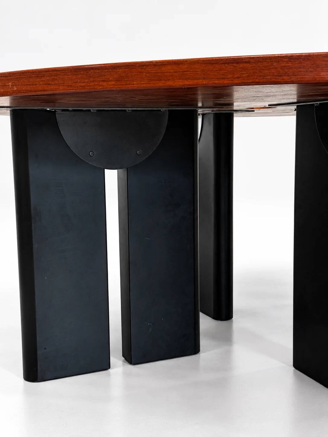 Large round dining table with black blade legs.