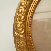 Large old oval gilded wooden frame and stucco decorations