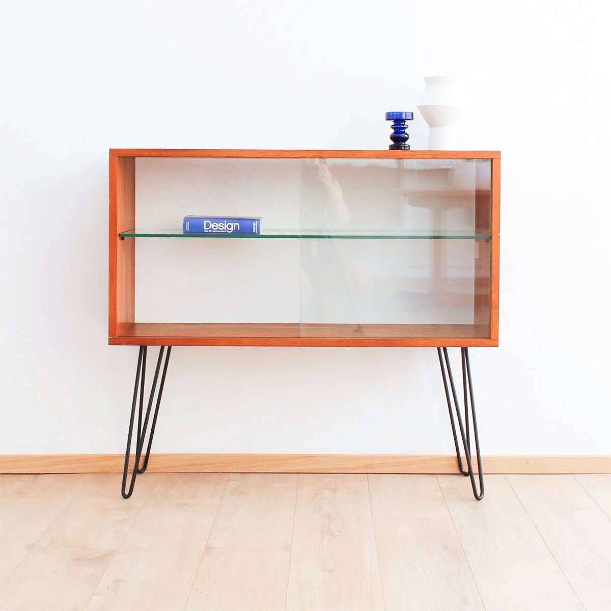 Teak display cabinet with black hairpin legs.