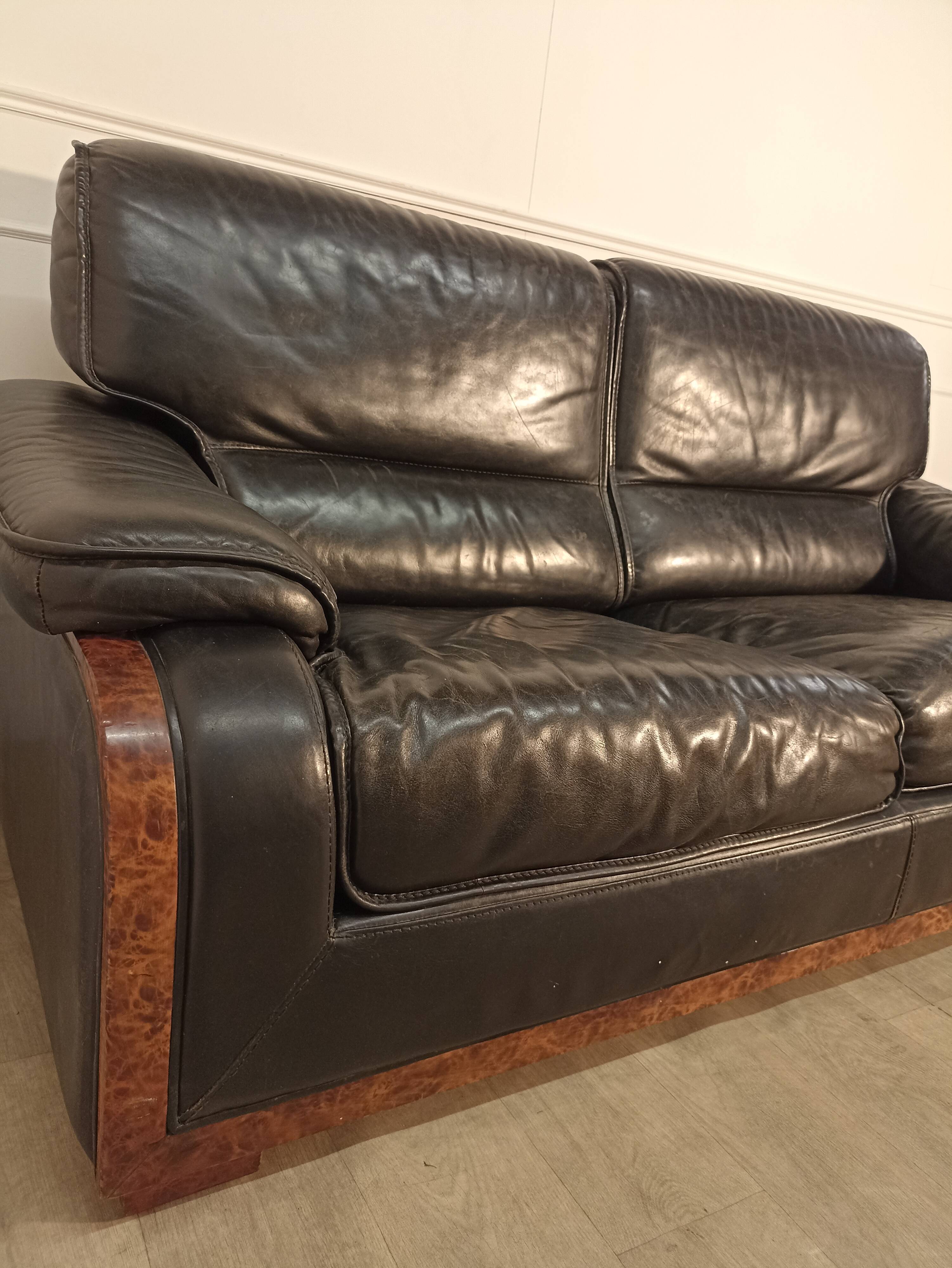 Black leather sofa and wooden armrests