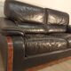 Black leather sofa and wooden armrests