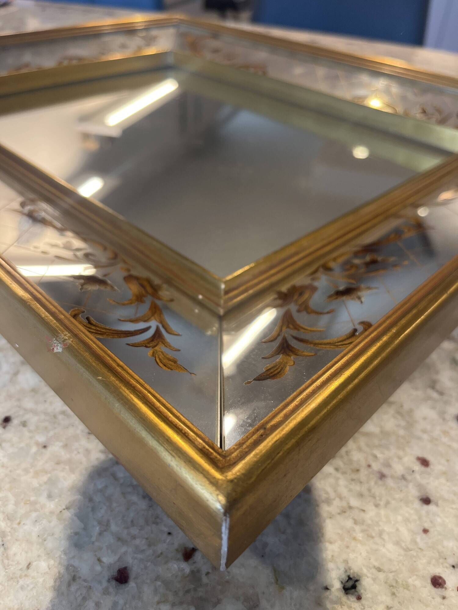 Large Venetian-style mirror with golden floral decoration.