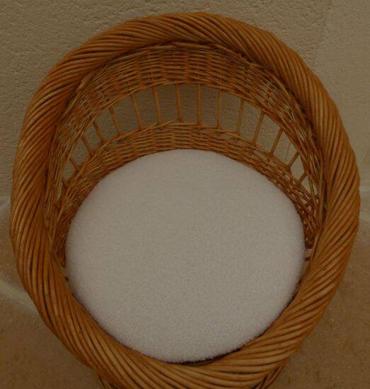 Wicker armchair with a high back and its boucle fabric cushion.