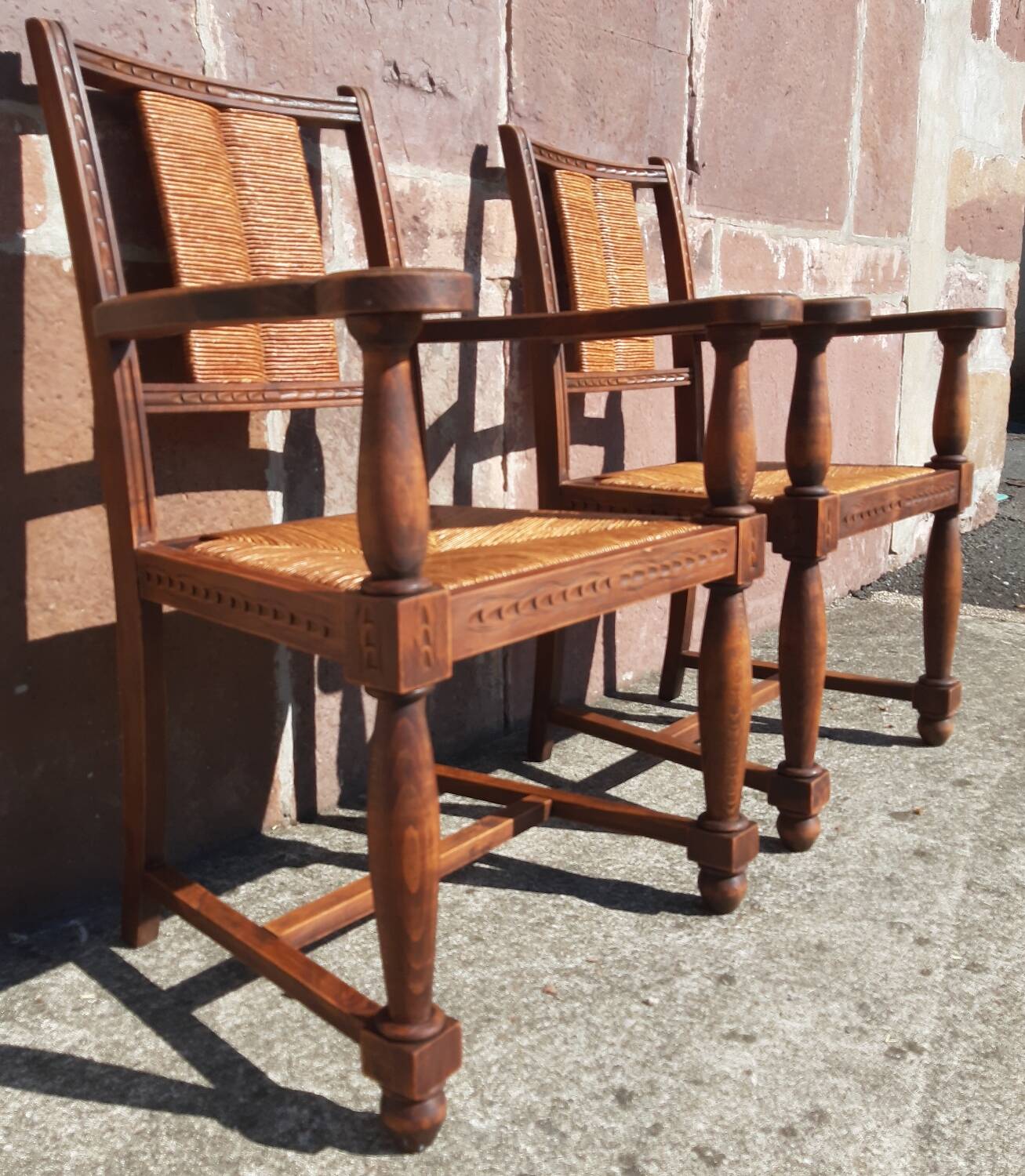 Pair of oak armchairs with straw seats and backs.