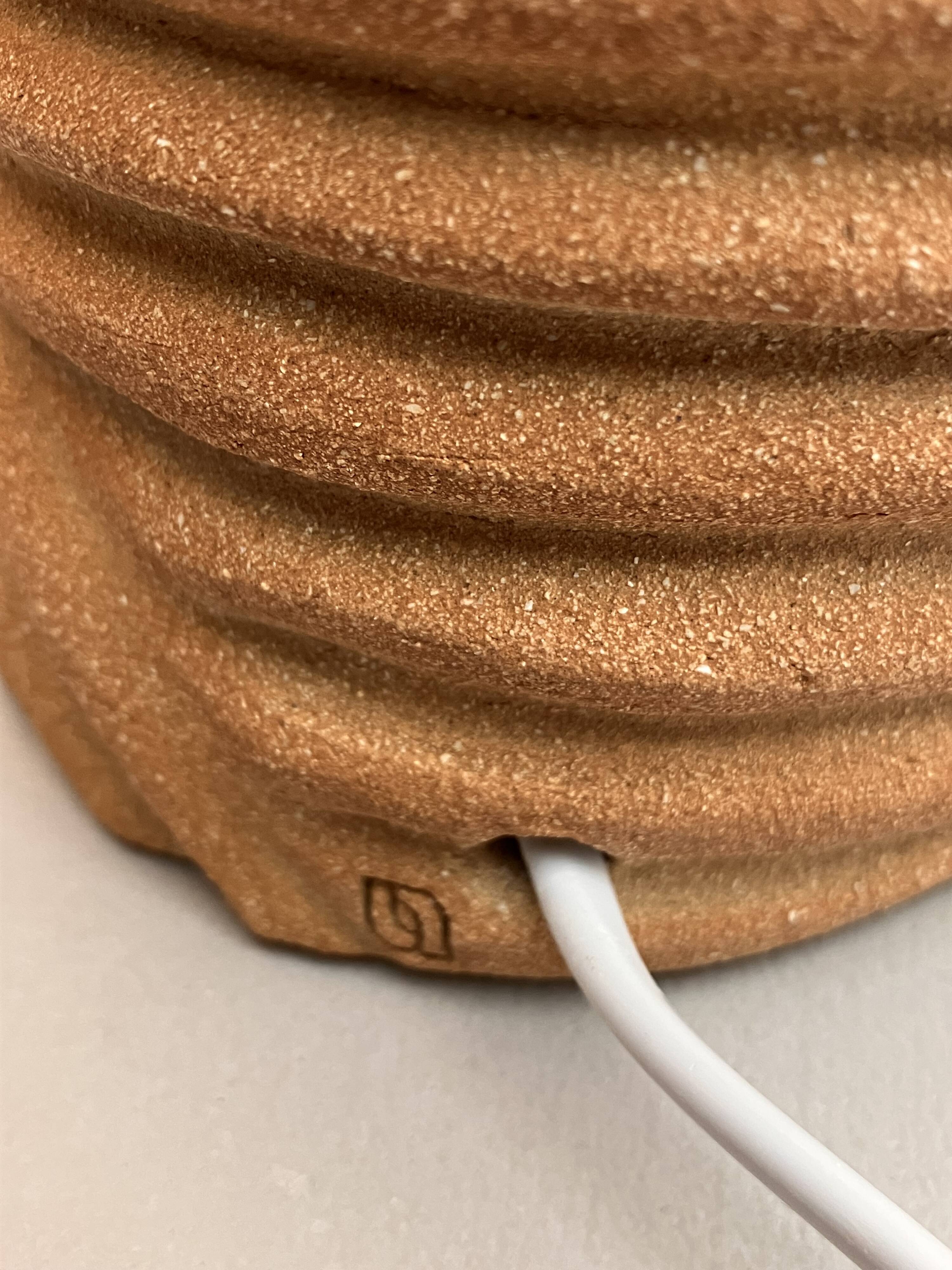 Oval table lamp in handcrafted ceramic with draped effect.