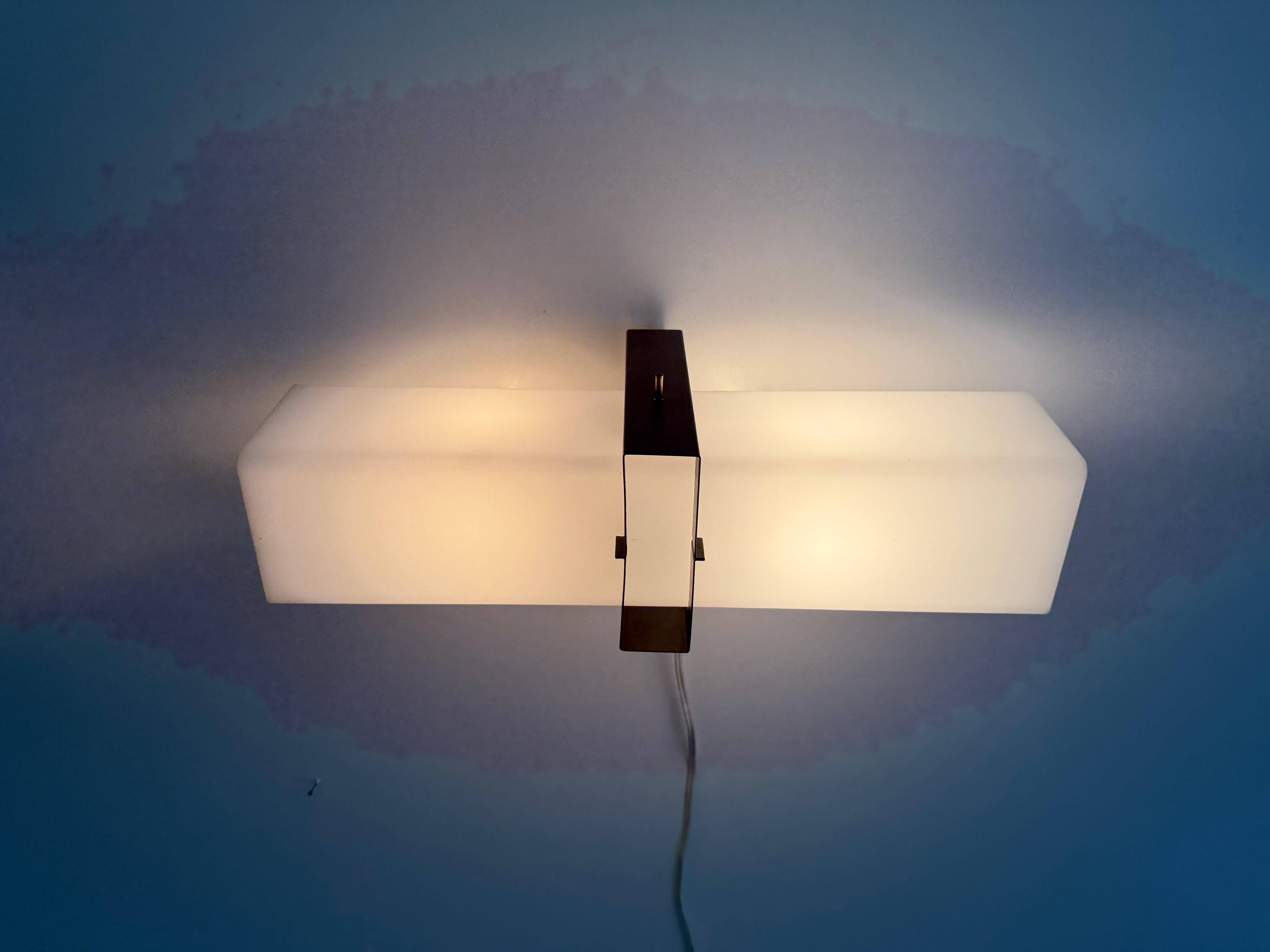 Simple white plexiglass wall light with a black metal frame, 1970s, Germany.