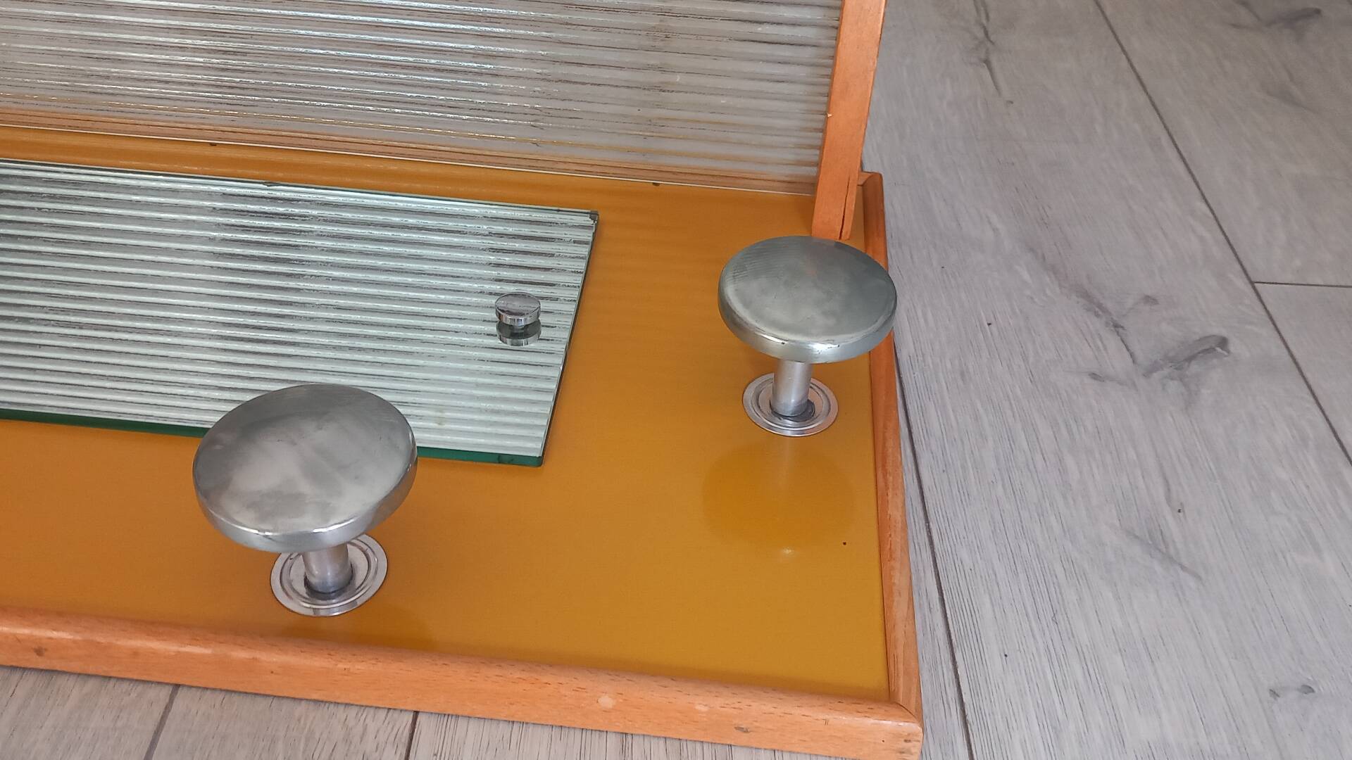 1950s coat rack with mirror, metal hooks, and glass shelf.