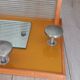 1950s coat rack with mirror, metal hooks, and glass shelf.