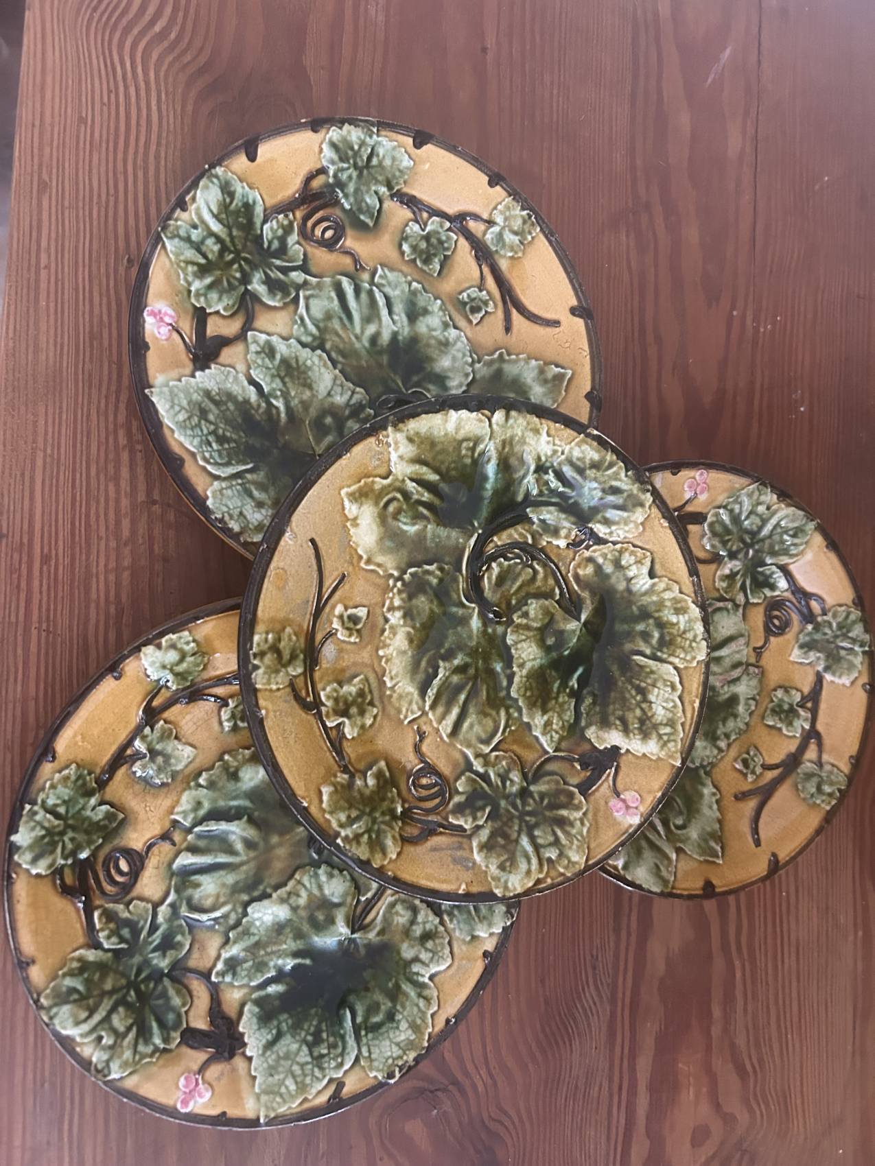 Four antique dessert plates in majolica with vine decoration.