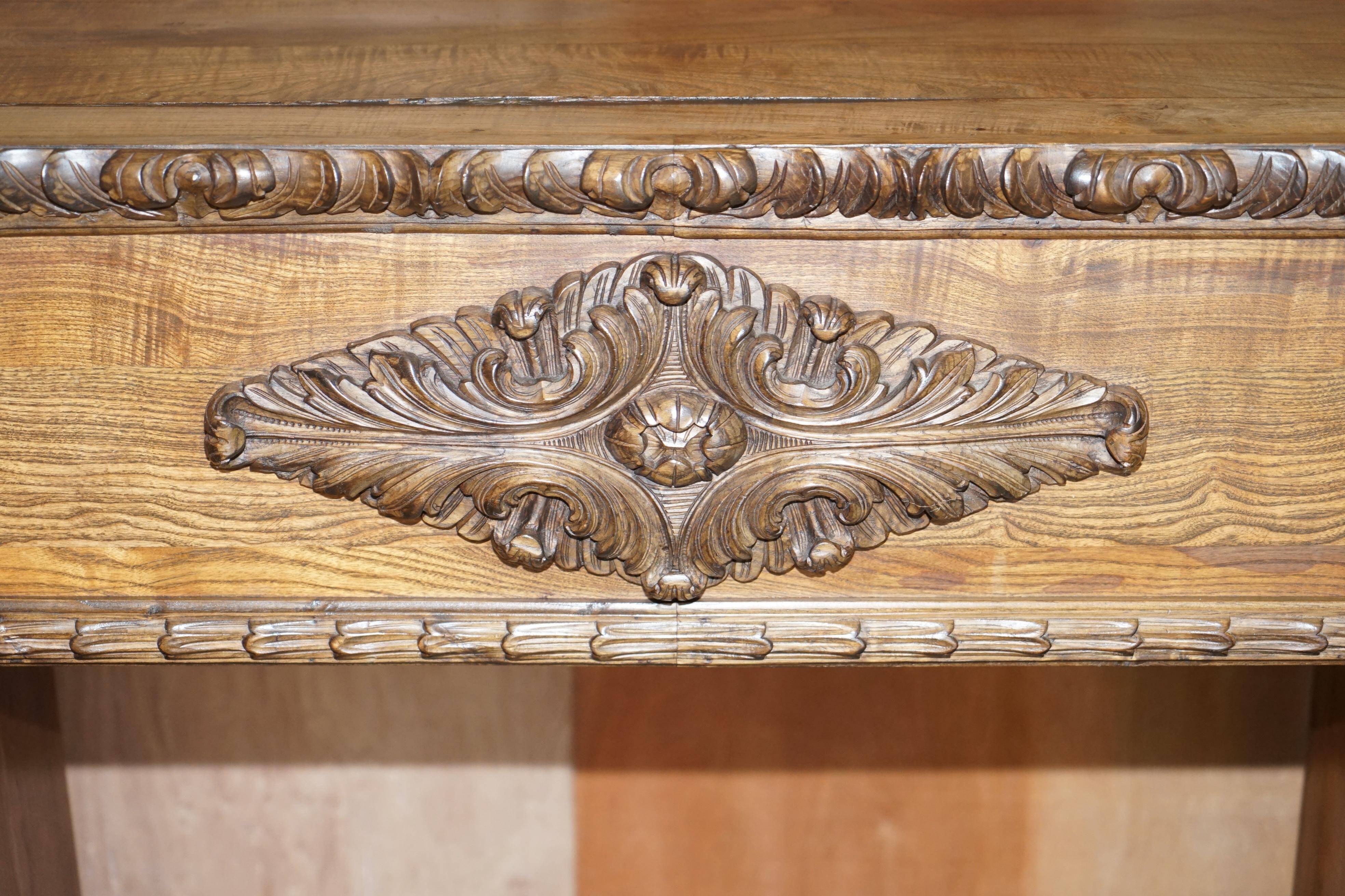 Antique fireplace from around 1880 in solid hand-carved elm with openwork columns.