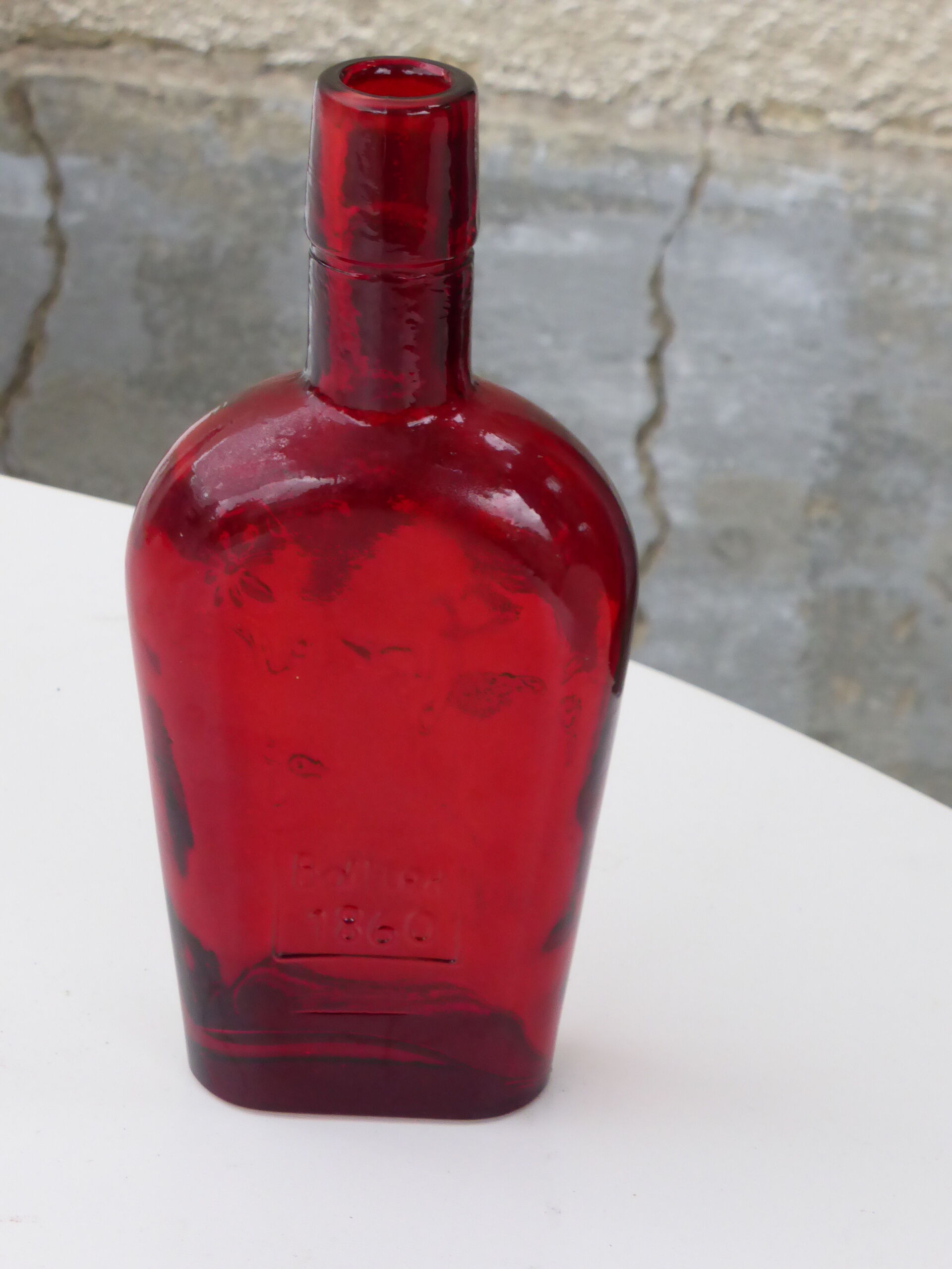 Glass bottle with red glass liqueur, old