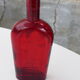 Glass bottle with red glass liqueur, old