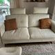 Ecru leather 2.5-seater sofa with walnut armrests.