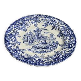 Une assiette à décor bleu en faïence BP à motif de fêtes villageoises