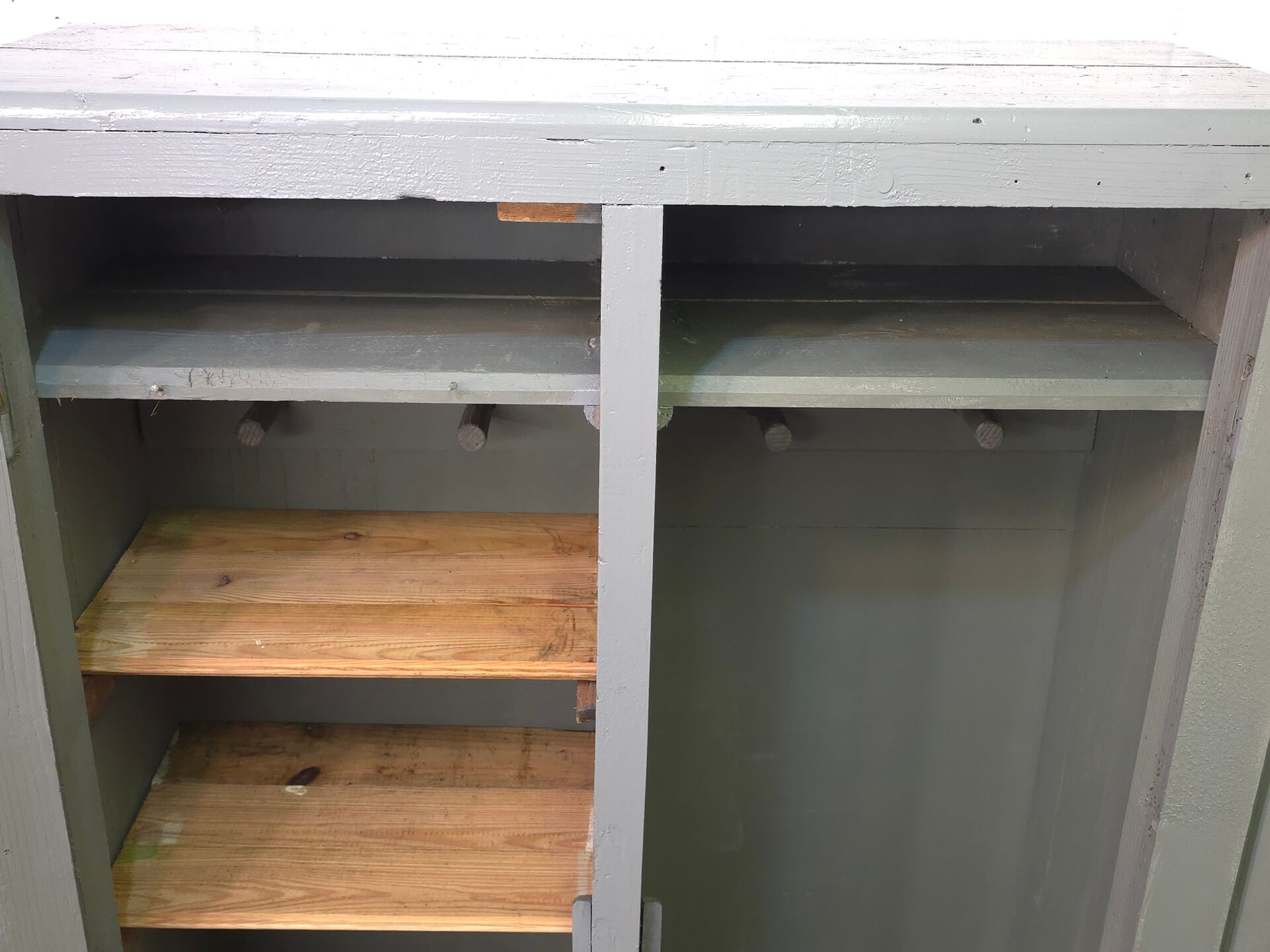 Curved wardrobe workshop locker made of wood repainted in grey.