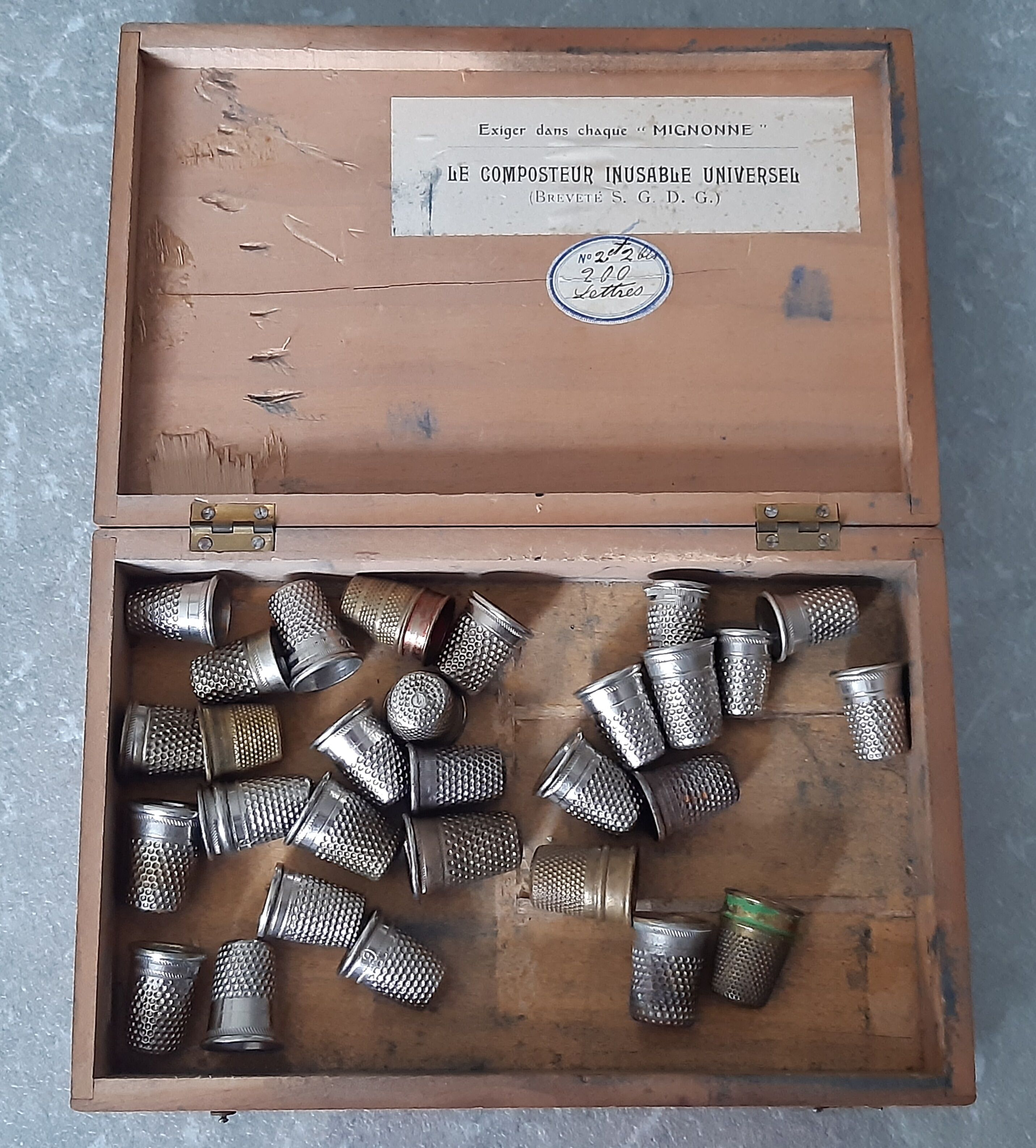 Wooden box containing 30 antique thimbles