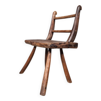 Rustic Wabi-Sabi style accent chair in dark curved hardwood, 1900s.