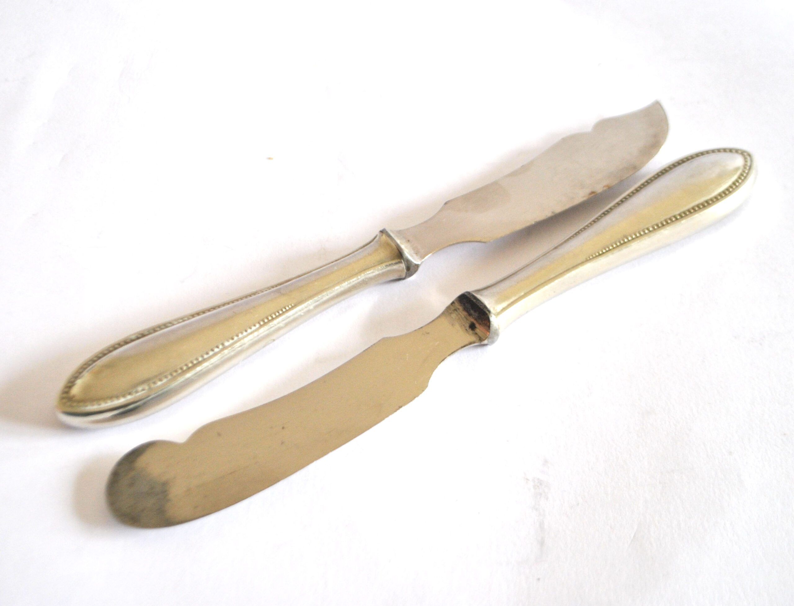 Two antique service knives in silver-plated metal, pearl frieze gowe alpacca.