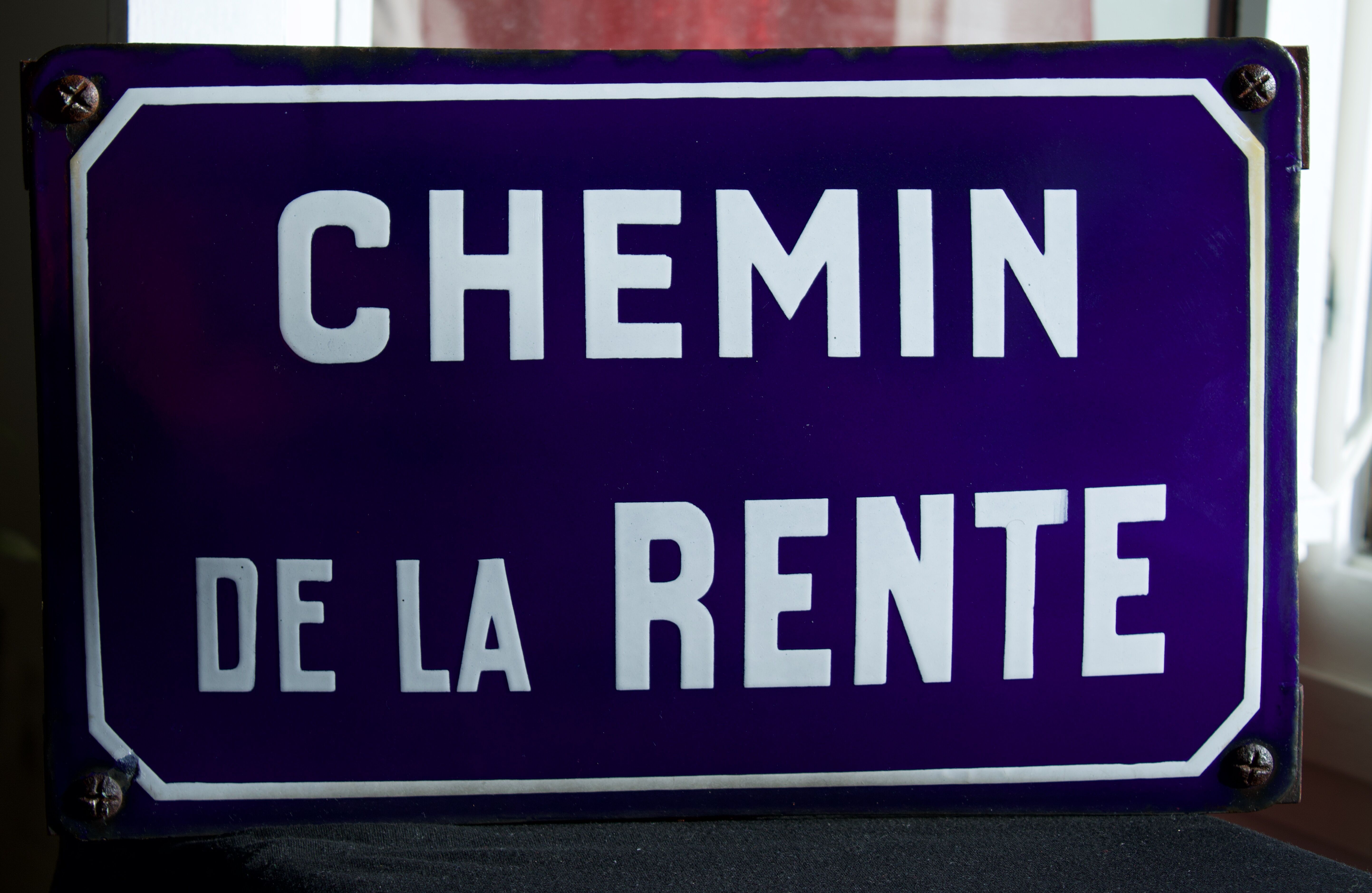 Old Enamelled and bulging "Chemin de la Rente" street plate, in perfect condition, on its cast iron support