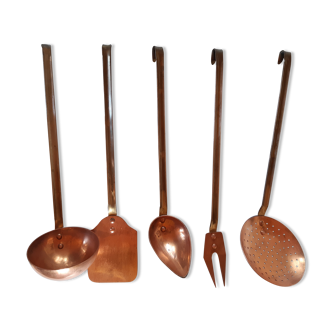 Copper kitchen utensils with their wall support