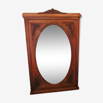 Old oval walnut wood mirror has flower carvings decoration