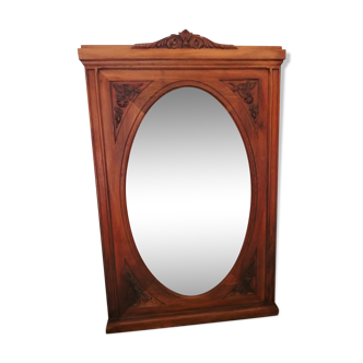 Old oval walnut wood mirror has flower carvings decoration