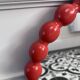 Round wall mirror with red beads in vintage retro design style.