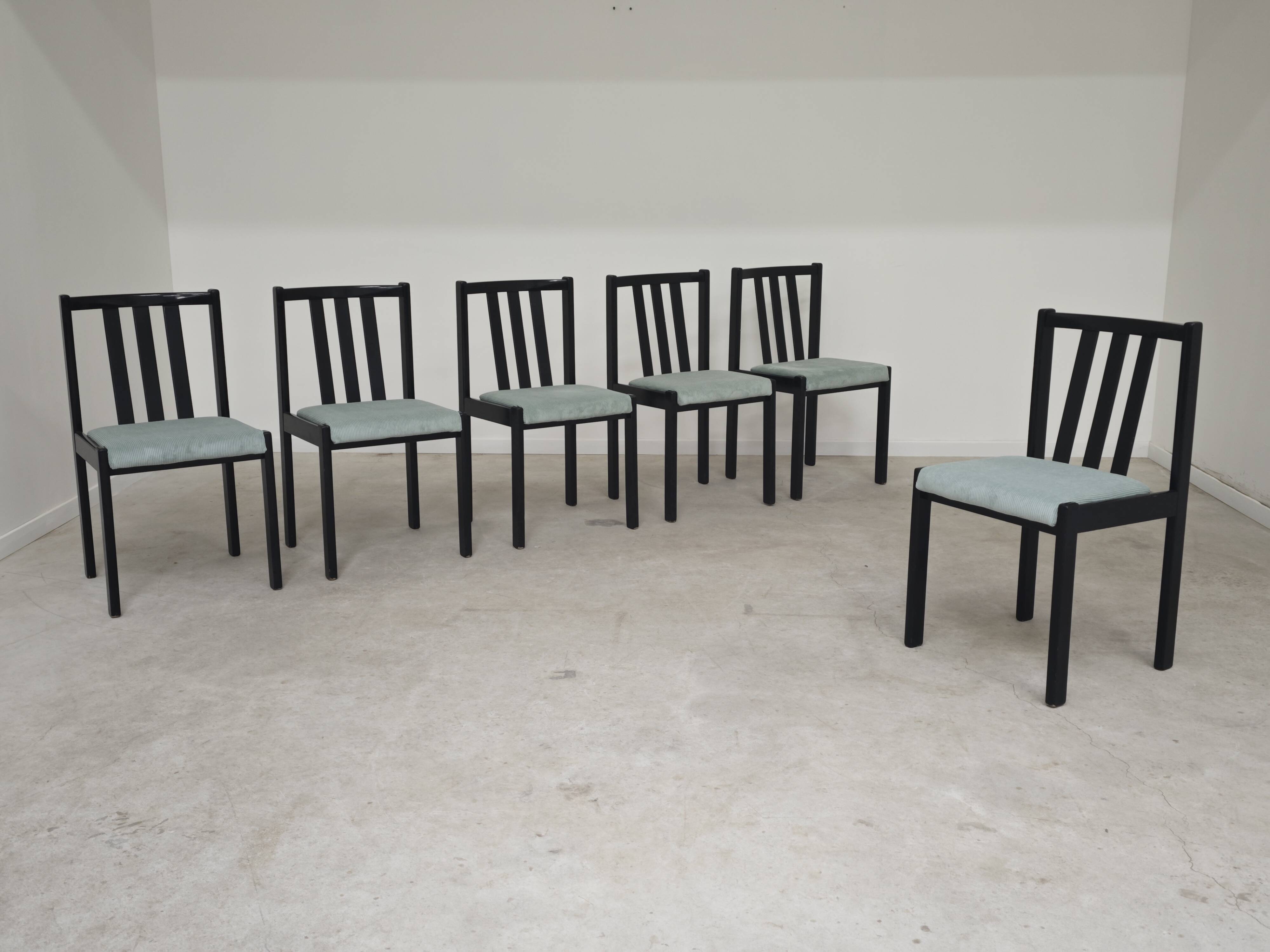 Set of 6 modernist black chairs with light blue-green ribbed fabric.