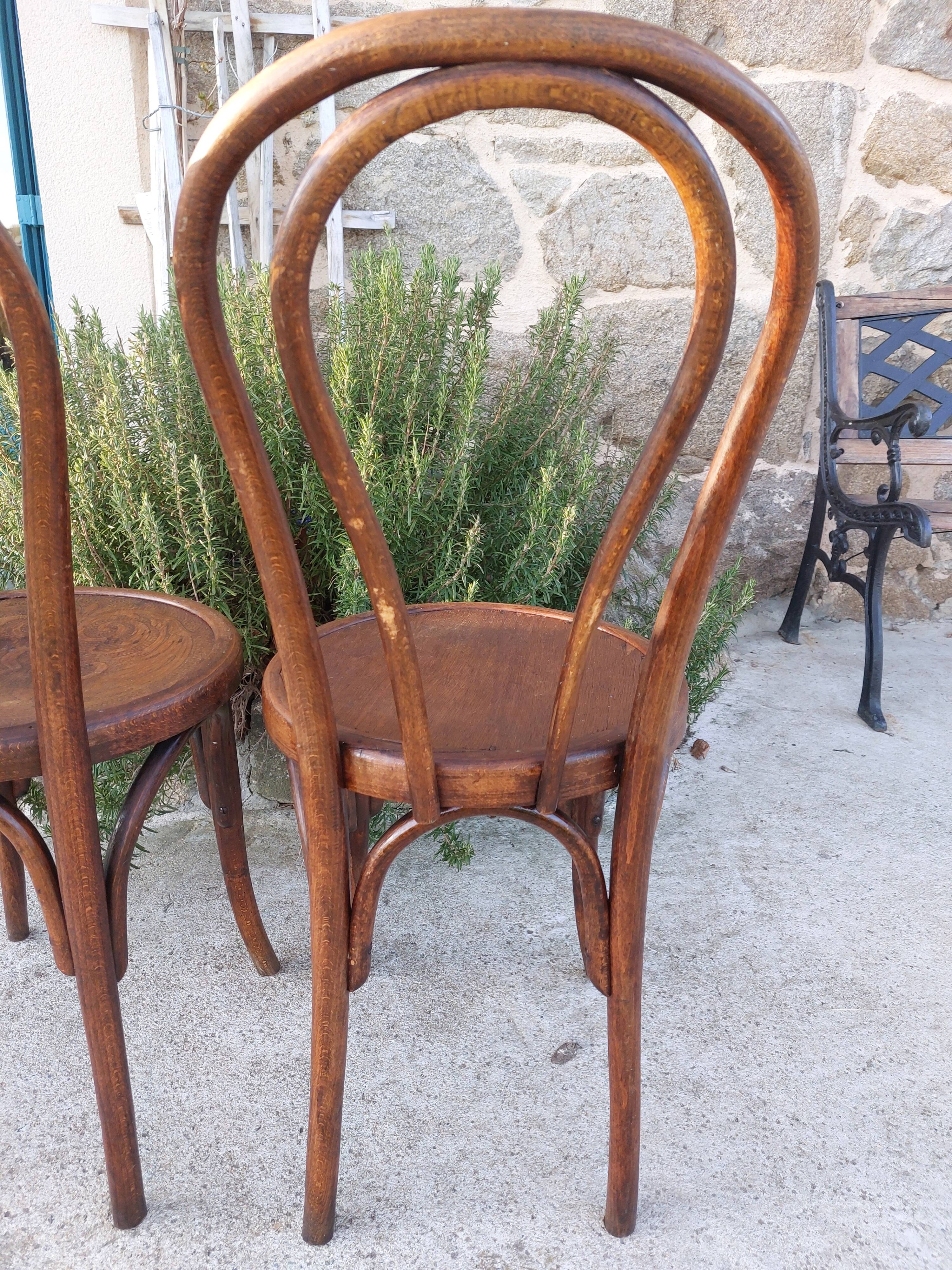 pair of round wooden chairs with a pattern on the seat