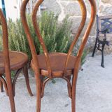 pair of round wooden chairs with a pattern on the seat