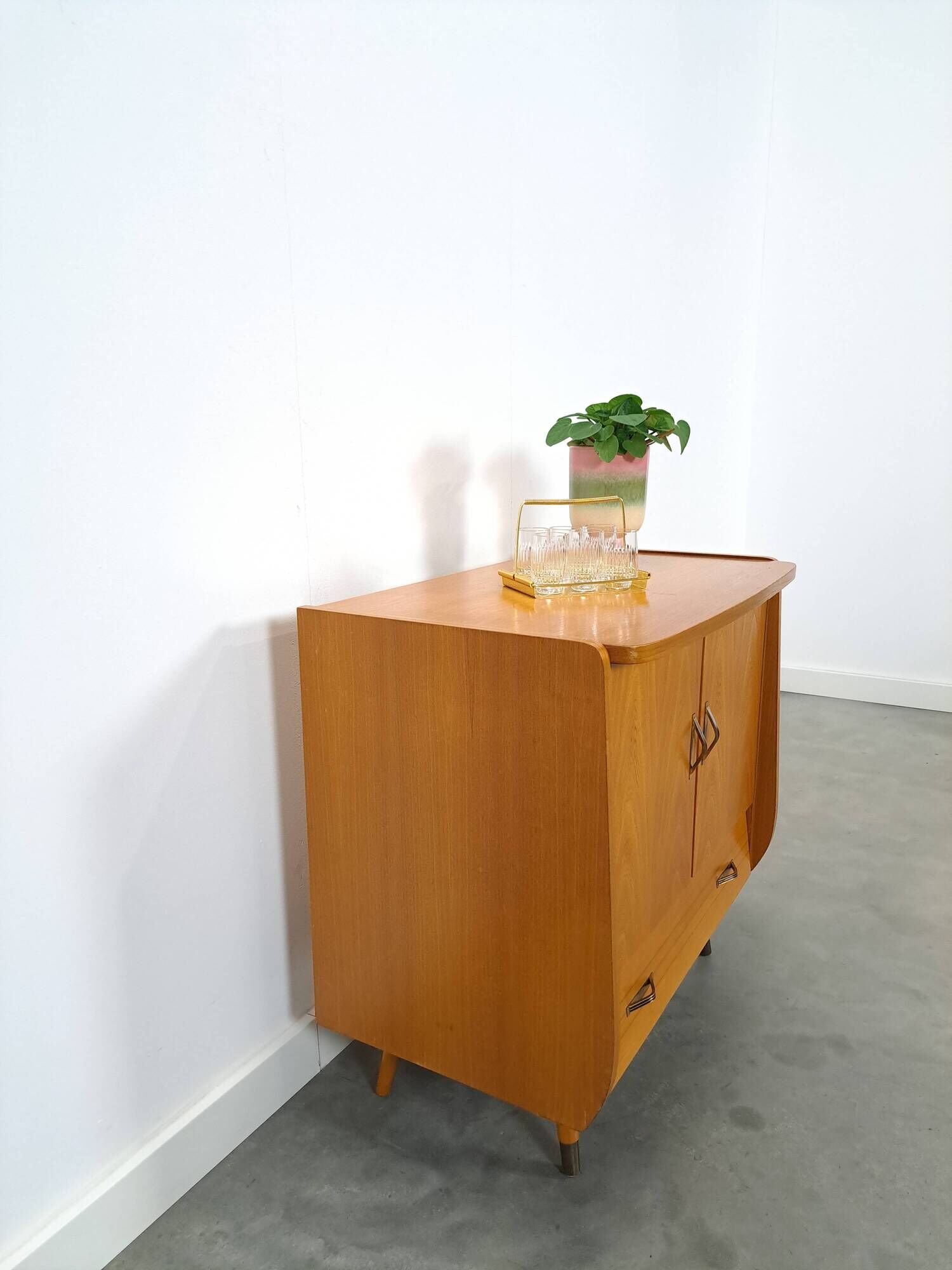 Meuble TV audio avec poignées en laiton et pieds inclinés.