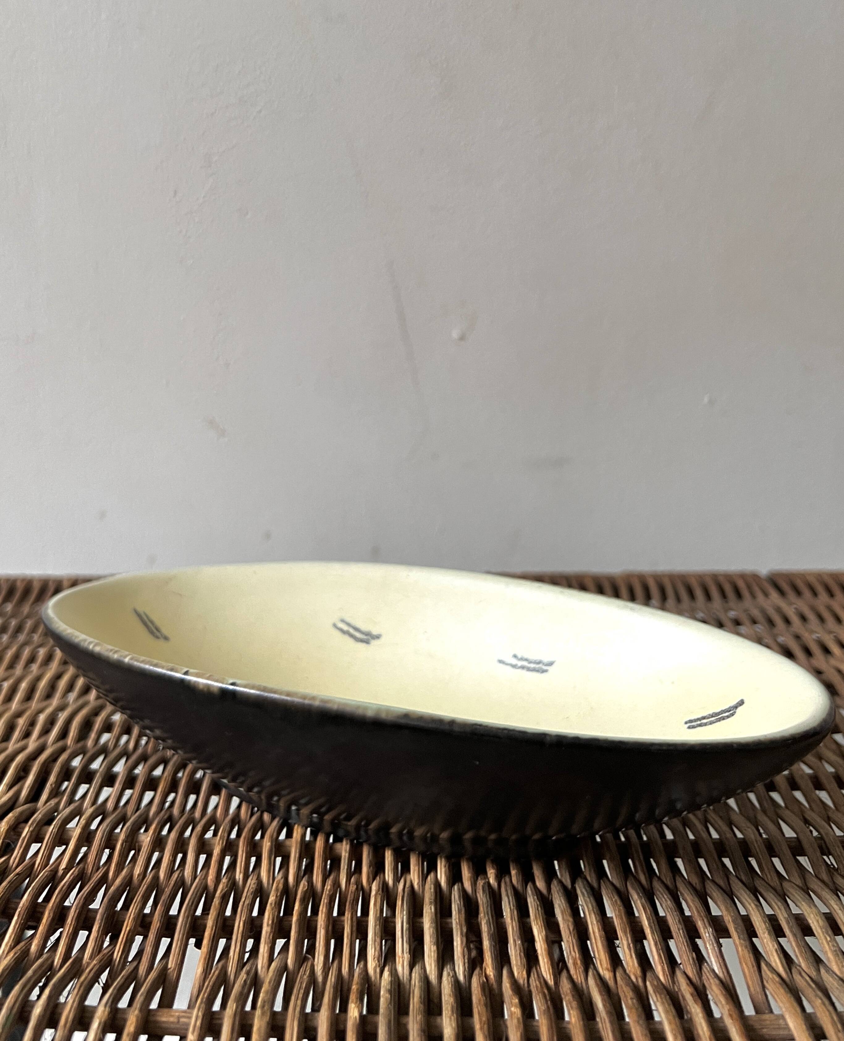 Pale yellow and black ceramic bowl / empty pocket signed by the artist
