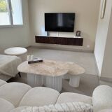 Oval coffee table duo travertine and white fluted wooden legs.