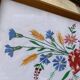 Tableau brodé Kalocsa multicolore sur fond blanc, cadre bois et verre, vintage années 1950
