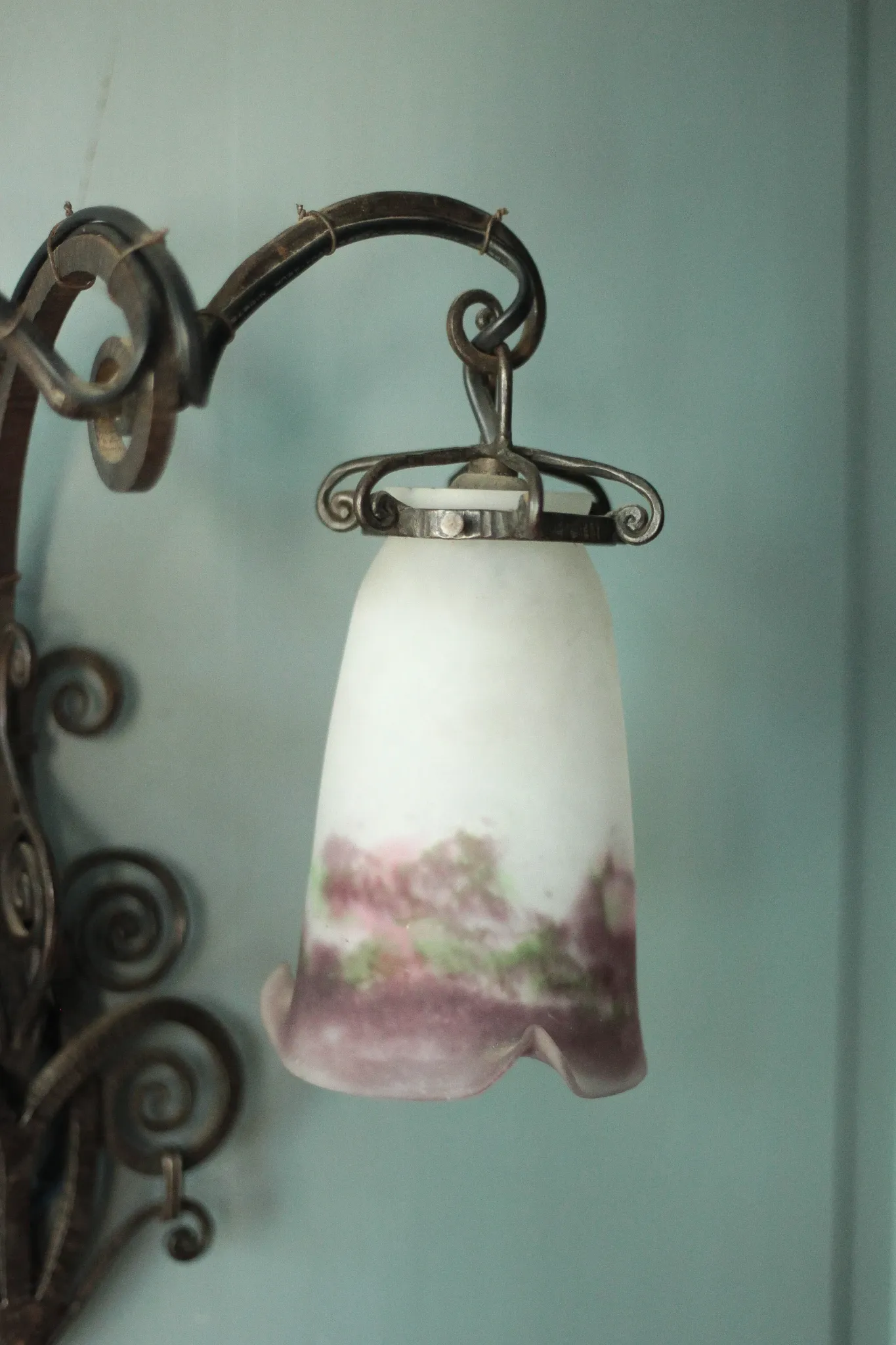Wall lamp in wrought iron with a pink tulip glass globe by Muller glassworks.