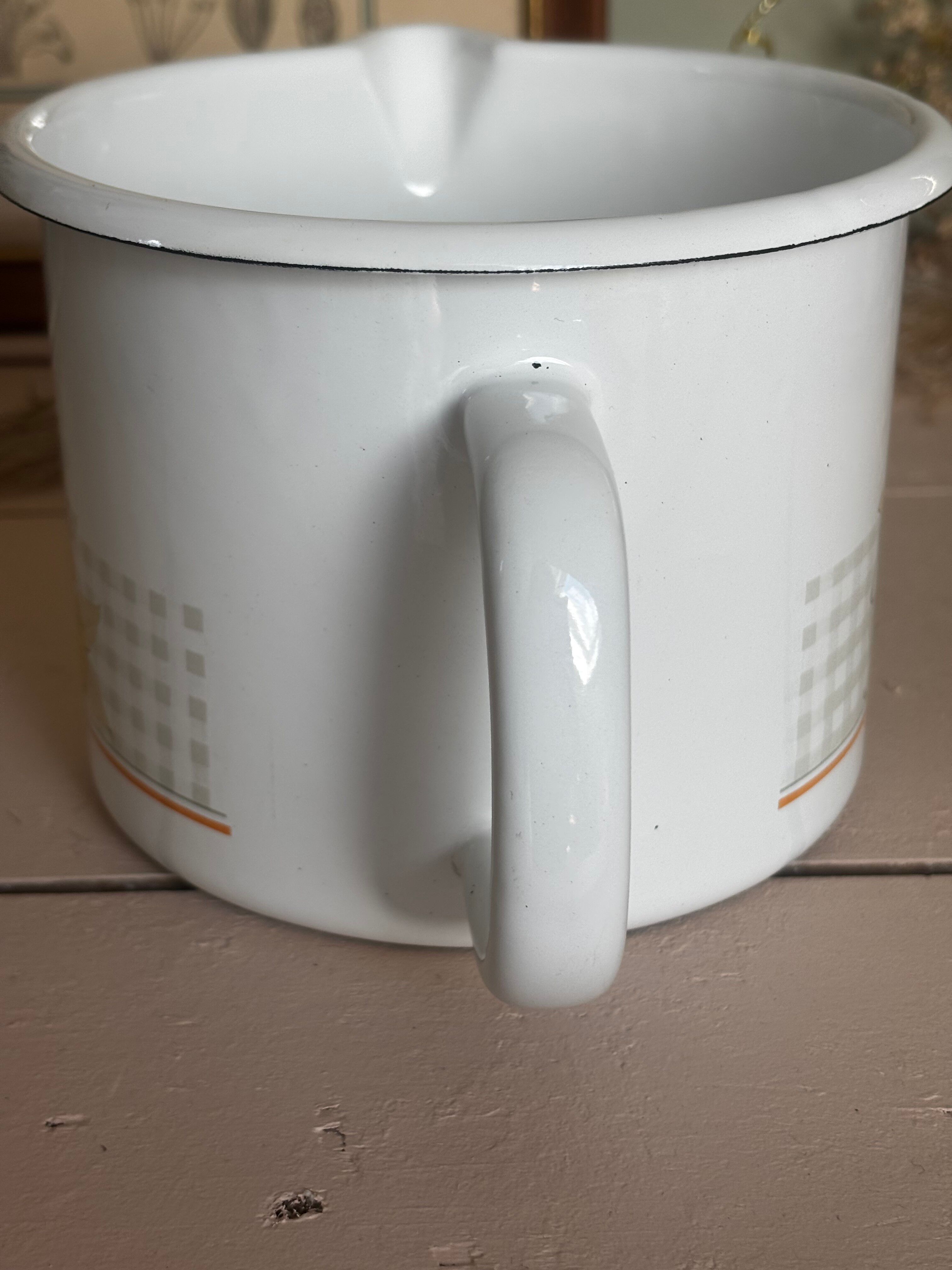 Vintage enamelled white metal milk jug with fruits.